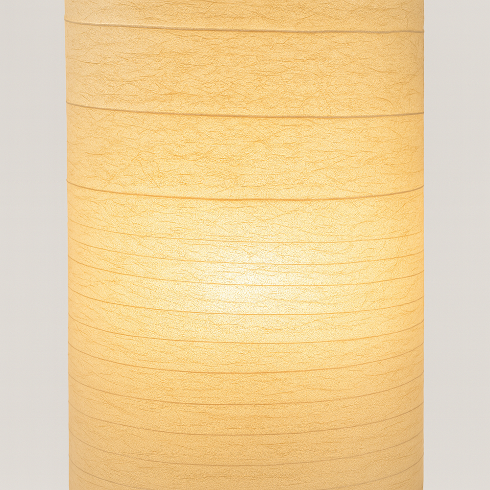 Tall sculpted floor lamp with beige textured fabric shade, 107 cm height, USB-powered with remote control, glowing warmly against a plain background.