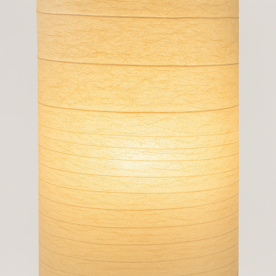 Tall sculpted floor lamp with beige textured fabric shade, 107 cm height, USB-powered with remote control, glowing warmly against a plain background.