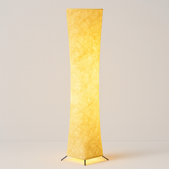 Tall sculptural floor lamp with textured fabric shade, glowing warmly at 130 cm height, shown against a softly lit interior background.